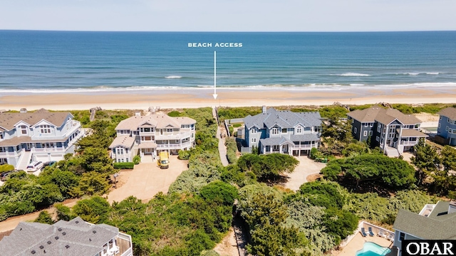 drone / aerial view featuring a view of the beach, a residential view, and a water view