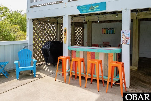 view of patio with area for grilling and outdoor dry bar