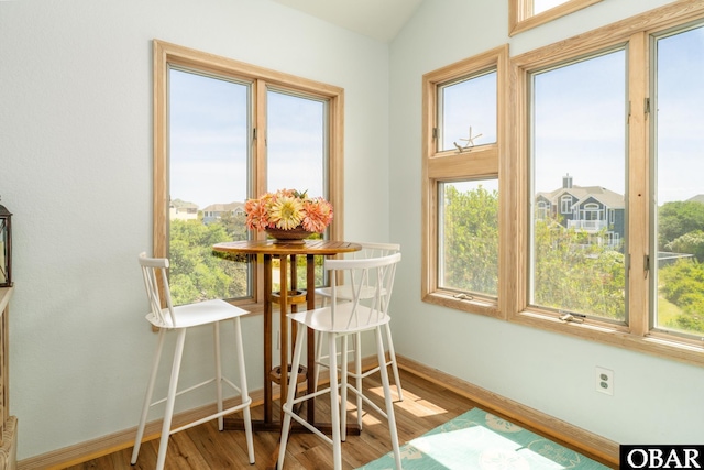 dining space with baseboards and wood finished floors