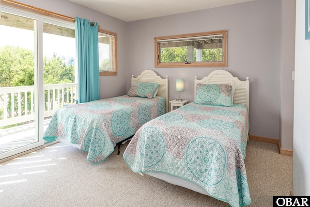 carpeted bedroom featuring baseboards, multiple windows, and access to exterior