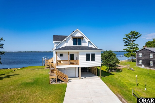 view of front of home with a water view, board and batten siding, driveway, a front lawn, and stairs