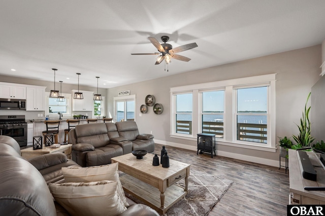 living room featuring dark wood-type flooring, recessed lighting, ceiling fan, and baseboards