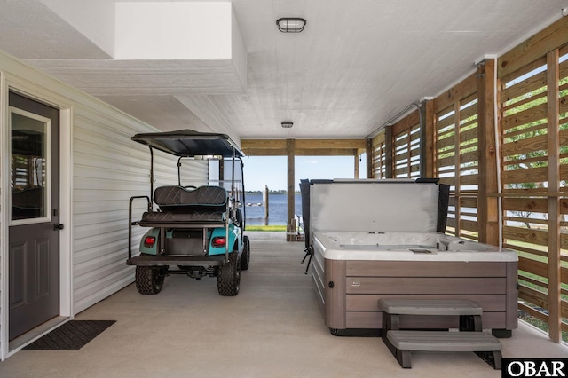 view of patio / terrace with a water view and a hot tub