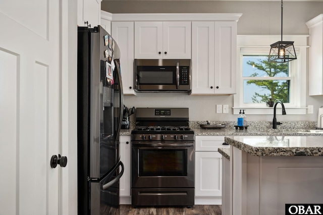 kitchen featuring stainless steel appliances, a sink, and white cabinets