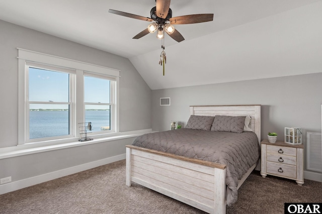 bedroom with dark colored carpet, visible vents, vaulted ceiling, and baseboards