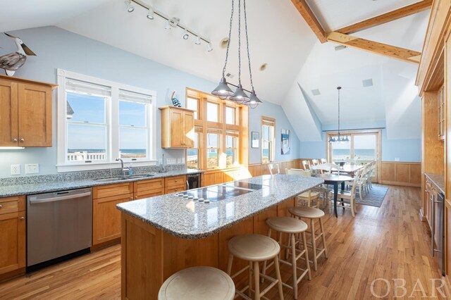 kitchen with black electric cooktop, a sink, hanging light fixtures, stainless steel dishwasher, and a center island