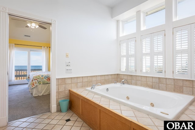 bathroom featuring connected bathroom, a water view, visible vents, tile patterned floors, and a tub with jets