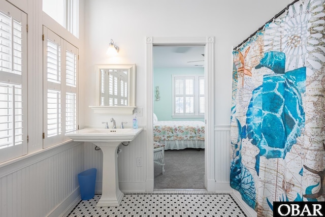 ensuite bathroom with tile patterned flooring, wainscoting, and connected bathroom