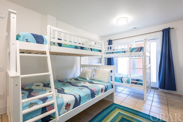 bedroom with light tile patterned floors, multiple windows, and visible vents