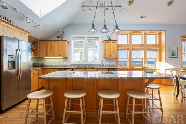 kitchen featuring a kitchen island, a sink, visible vents, appliances with stainless steel finishes, and open shelves