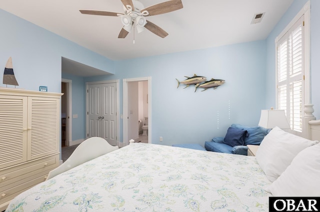 bedroom featuring ensuite bathroom, visible vents, and a ceiling fan