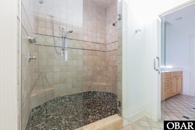 bathroom with baseboards, vanity, a shower stall, and tile patterned floors