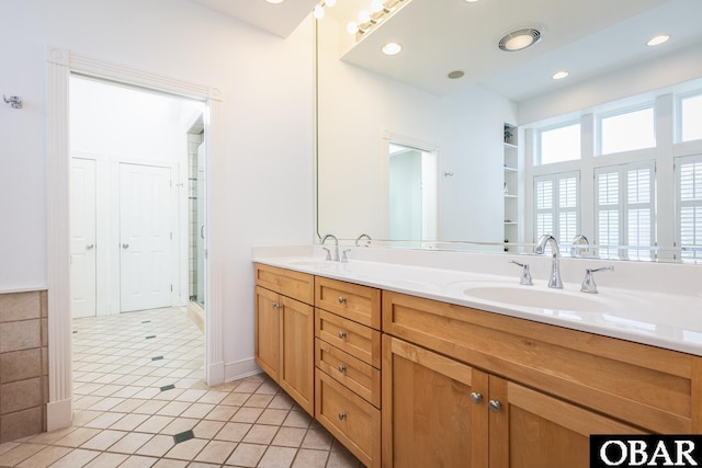 bathroom with double vanity, a stall shower, a sink, and recessed lighting