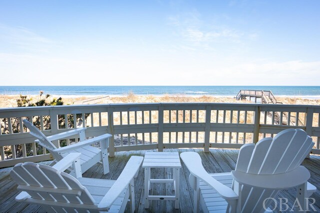 wooden deck with a view of the beach and a water view