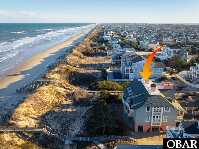 drone / aerial view featuring a water view, a residential view, and a view of the beach