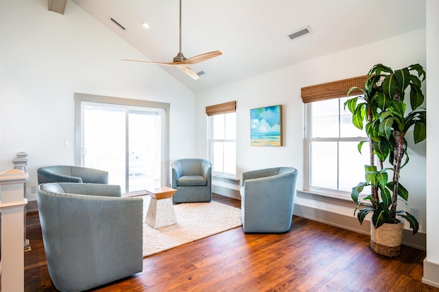 living room with a ceiling fan, visible vents, dark wood-type flooring, and a wealth of natural light