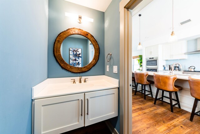 bathroom featuring vanity, wood finished floors, and visible vents