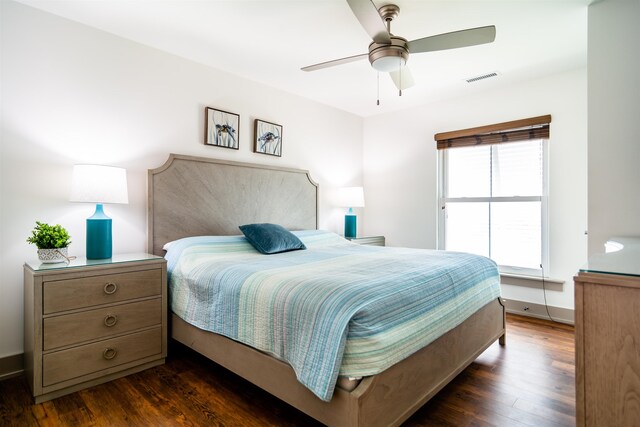 bedroom with a ceiling fan, dark wood finished floors, visible vents, and baseboards