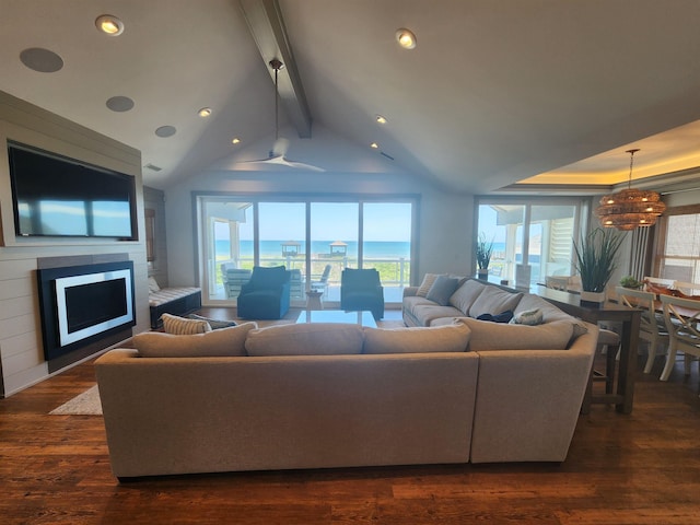 living room featuring dark wood finished floors, a healthy amount of sunlight, a fireplace, and lofted ceiling with beams