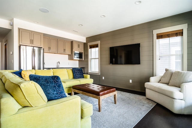 living area with recessed lighting, a healthy amount of sunlight, and wooden walls