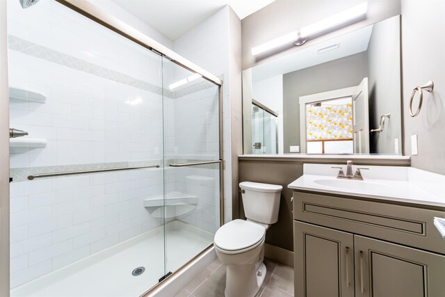 full bathroom featuring toilet, tile patterned floors, a shower stall, and vanity