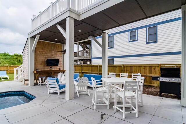 view of patio / terrace with outdoor dining area, exterior bar, area for grilling, fence, and a swimming pool