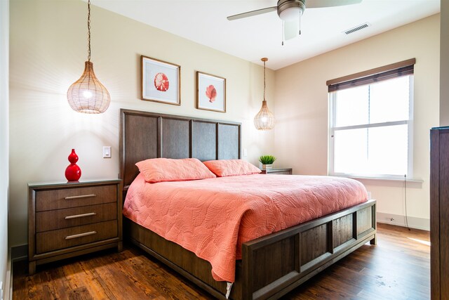 bedroom featuring dark wood-style floors, visible vents, ceiling fan, and baseboards