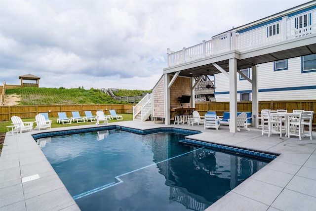 view of pool featuring stairway, an outdoor bar, fence, and a fenced in pool