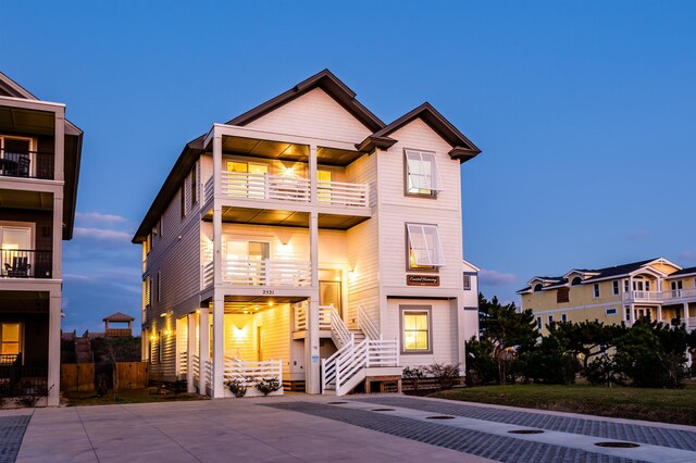 beach home with concrete driveway and a balcony