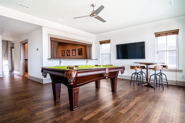 recreation room featuring plenty of natural light, dark wood finished floors, visible vents, and a ceiling fan