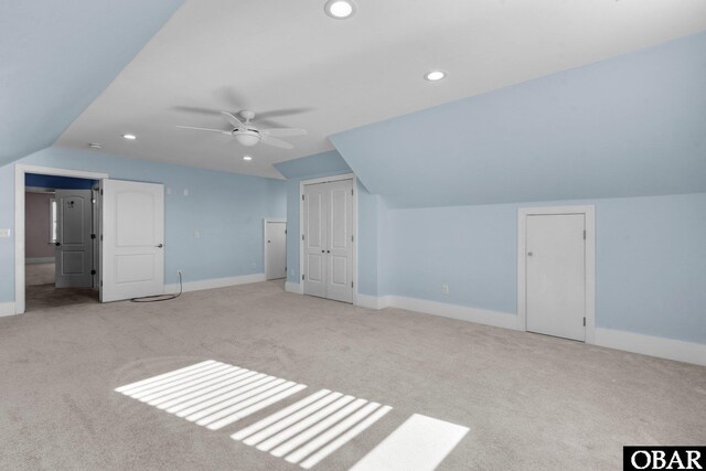 bonus room featuring baseboards, vaulted ceiling, and light colored carpet