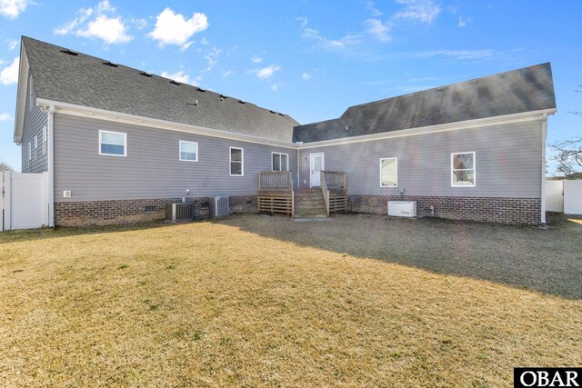 back of house featuring central AC unit, a shingled roof, fence, crawl space, and a lawn