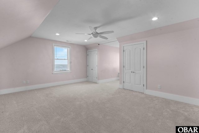 bonus room featuring light carpet, vaulted ceiling, a ceiling fan, and baseboards