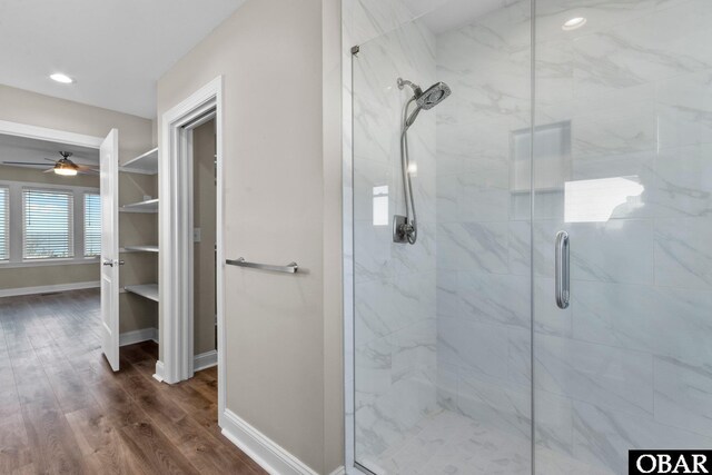 bathroom with ceiling fan, recessed lighting, wood finished floors, baseboards, and a shower stall