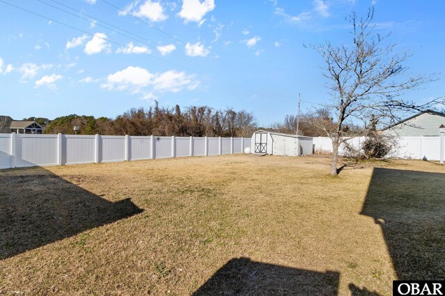 view of yard with a shed, an outdoor structure, and a fenced backyard