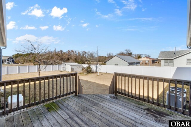 wooden deck featuring a residential view, a fenced backyard, and central AC unit