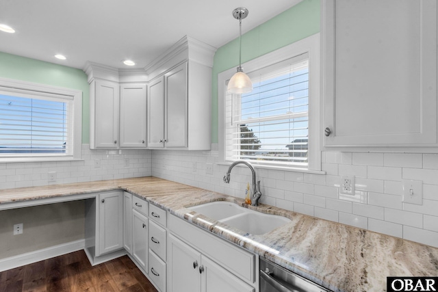 kitchen featuring decorative backsplash, white cabinets, decorative light fixtures, light stone countertops, and a sink