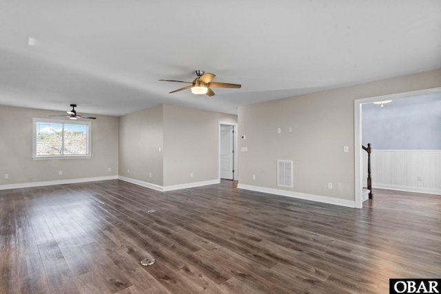 unfurnished living room featuring dark wood-type flooring, visible vents, ceiling fan, and baseboards