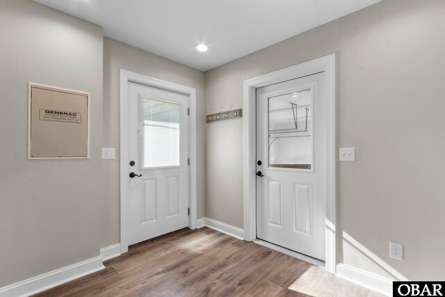 doorway to outside featuring wood finished floors and baseboards