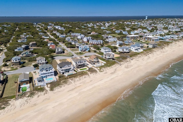 drone / aerial view with a residential view, a beach view, and a water view
