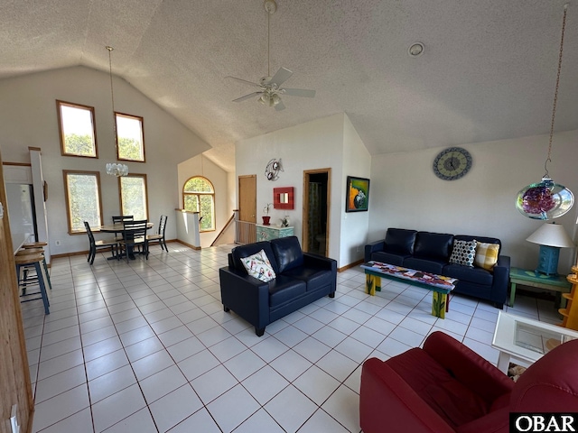 living room featuring a textured ceiling, baseboards, light tile patterned flooring, a ceiling fan, and high vaulted ceiling