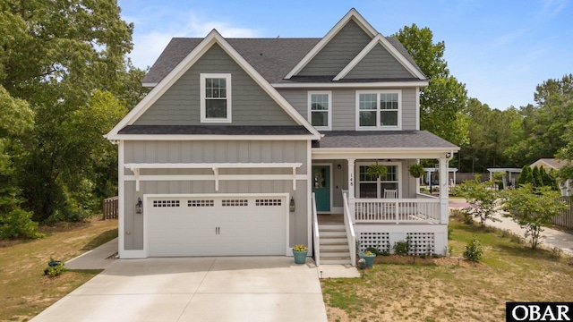 craftsman-style house with board and batten siding, a porch, a shingled roof, and driveway
