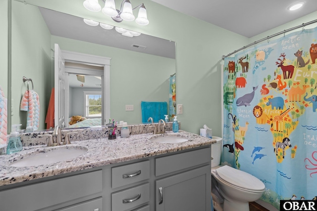 full bath featuring toilet and double vanity