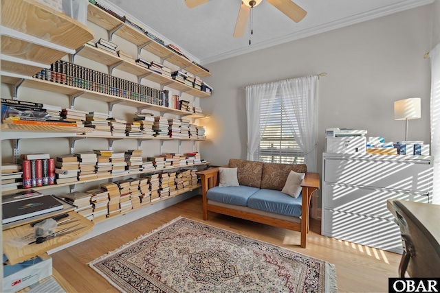 living area with ceiling fan, ornamental molding, and wood finished floors
