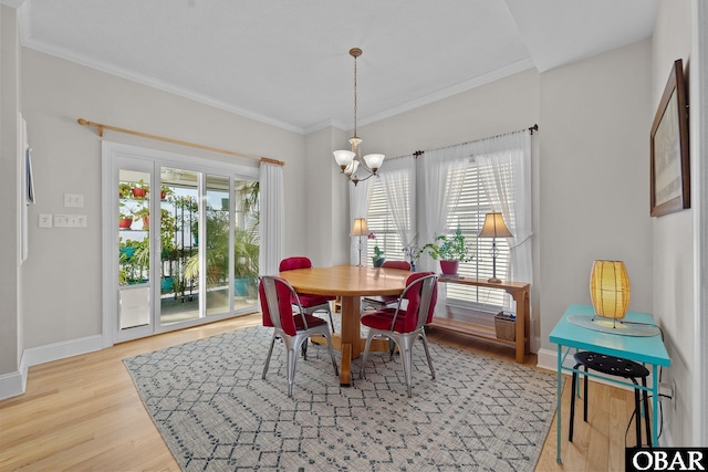 dining area featuring baseboards, an inviting chandelier, ornamental molding, and light wood-style flooring