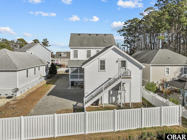 105 S Flats Ct Lot 16, Manteo, NC 27954 - rear view of property with stairway, a sunroom, a fenced backyard, and a residential view