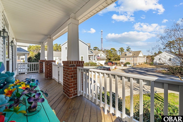 wooden terrace featuring covered porch and a residential view