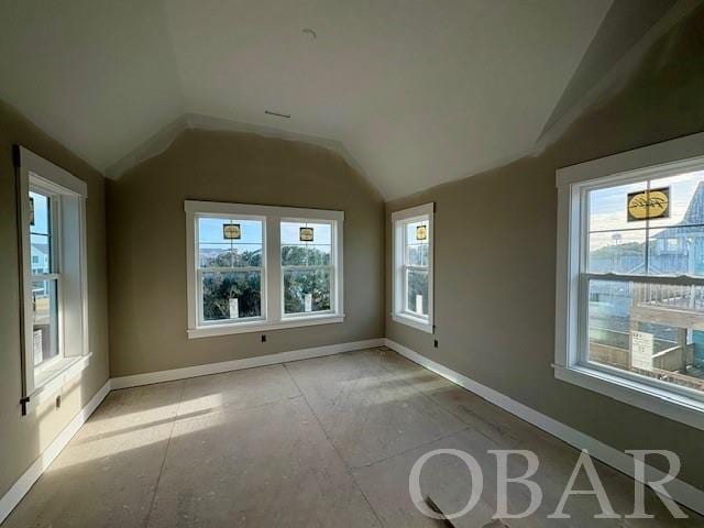 unfurnished sunroom featuring vaulted ceiling and plenty of natural light