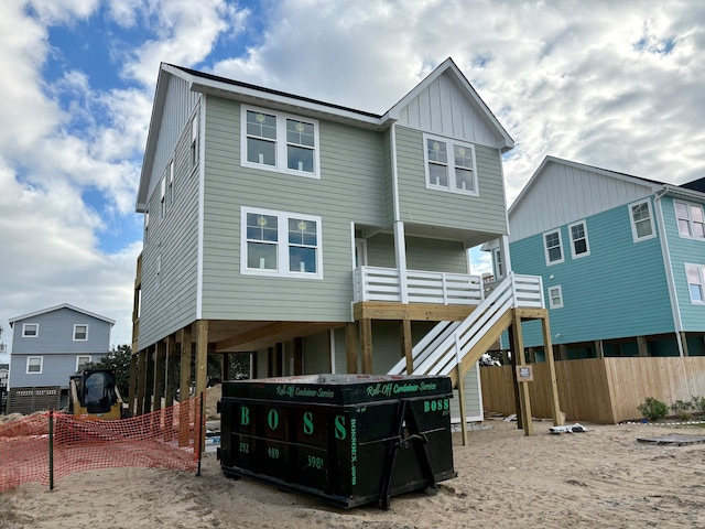 back of property with a carport, stairs, and board and batten siding