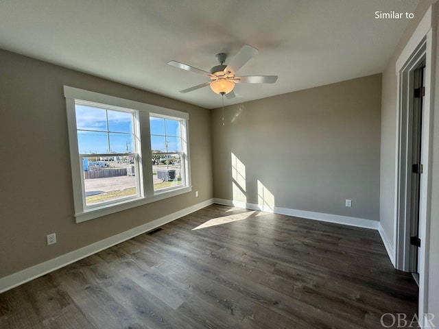 empty room featuring visible vents, dark wood finished floors, baseboards, and ceiling fan